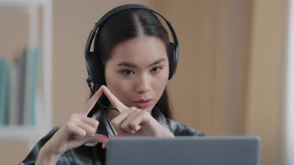 Asian Female Office Worker Wears Headset Has Distant Conference Video Calling with Laptop Computer
