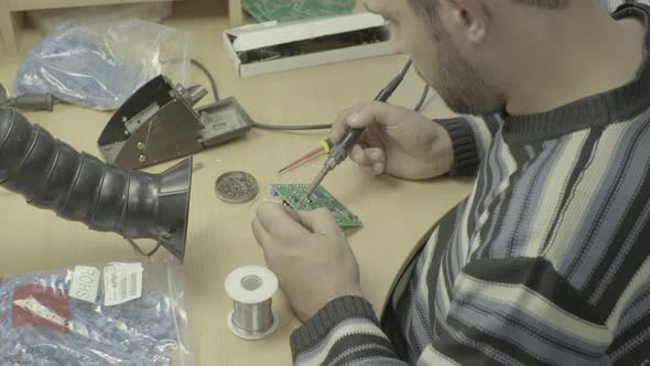 A Worker Is Working on the Production of an Electronic Board. Close-up.