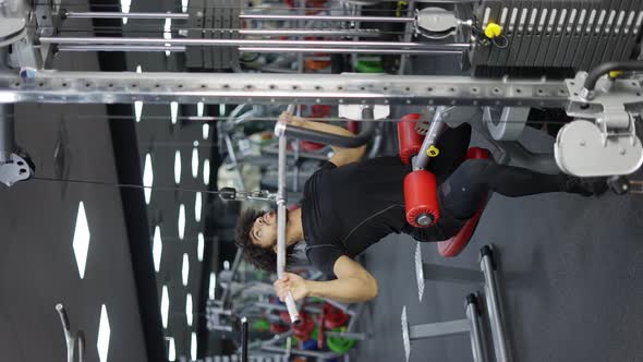 Young Man Exercising on Lateral Pull at Gym  Concept of Bodybuilding