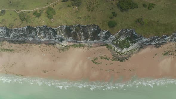 Cliff with Rural Nature, Turquoise Ocean and Green Meadow, Slow Aerial Overhead Top Down Birds View