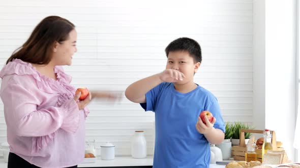 Fat mom and fat boy eating a fresh apple together, healthy fruit