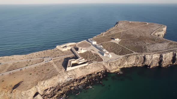 Aerial view of Fortaleza de Sagres buttressed fortress with two tones deep blue and turquoise ocean