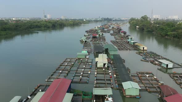 drone shot flying over floating fish farming community in Bien Hoa on the Dong Nai river, Vietnam on