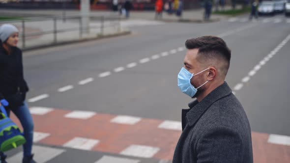 Street life during coronavirus pandemic. Man wearing mask crossing street during pandemic