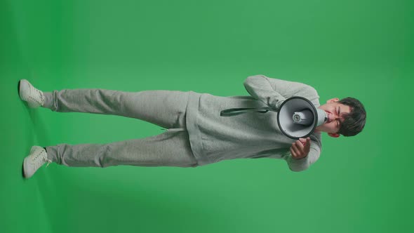 Full Body Of Asian Man Shouting On Megaphone In The Green Screen Studio