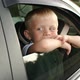 A Little Boy Sits in the Backseat of a Car He Looks Out the Window and Smiles - VideoHive Item for Sale