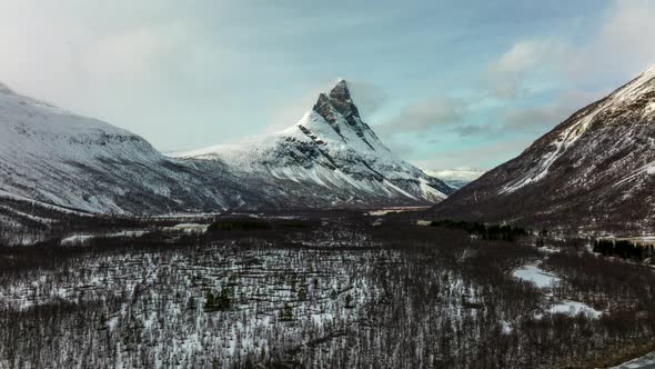 Drone hyperlapse from valley towards Otertinden mountain, snow landscape