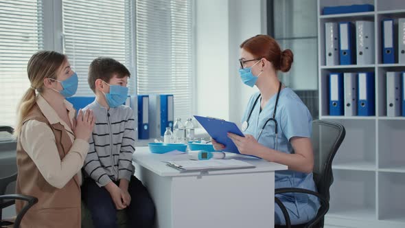 Consultation with a Doctor During Pandemic Female Physician in Medical Mask and Glasses is Talking