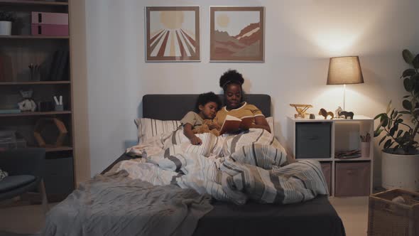 Aunt Reading Book to Sleeping Boy