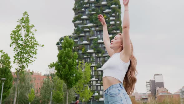 Slow motion young caucasian woman spreading arms breathing fresh air enjoying freedom