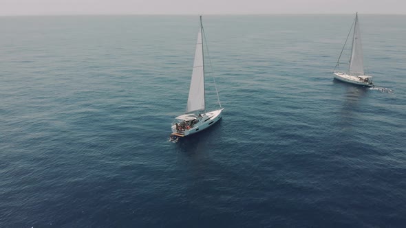 Aerial View of Two Yachts in the Ocean Silhouettes of Swimming People Next to Yachts