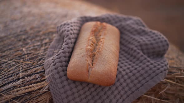 Closeup Tasty Bread Loaf Lying on Towel on Yellow Wheat Pile Outdoors