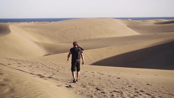 Man Walking In Sand Dunes