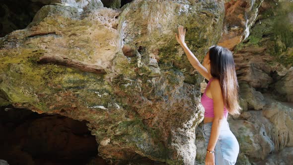 4K Young Asian woman walking in the cave at tropical island beach on summer vacation