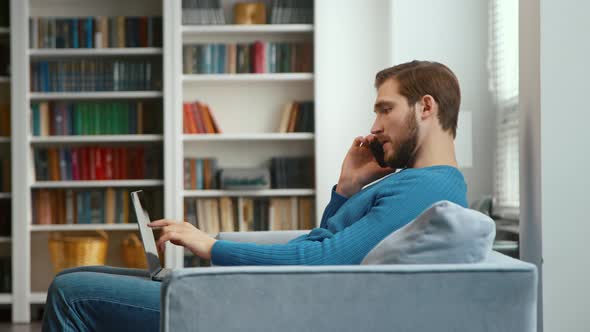 Young man talking on the phone in his home office