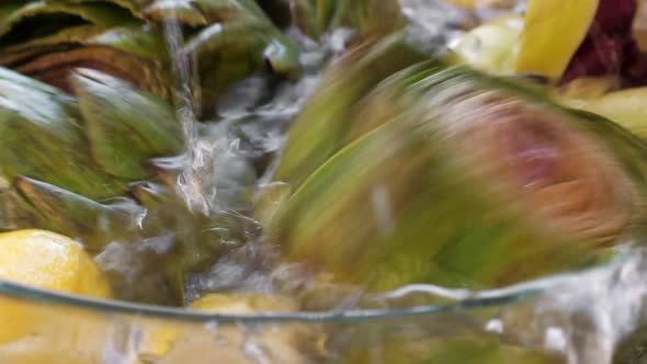 Artichokes Falling Down in Water at Glass Bowl