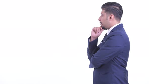 Profile View of Happy Bearded Persian Businessman Thinking