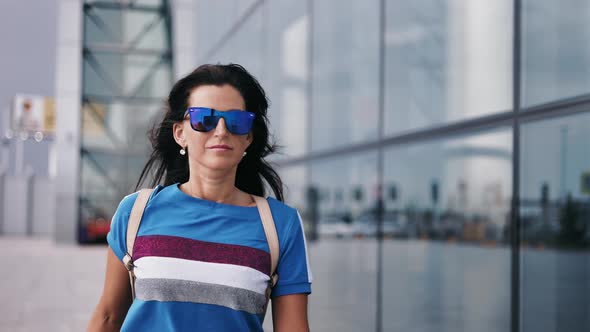 Confident Fashion Woman Tourist in Sunglasses Going Outdoor at International Airport Terminal Area