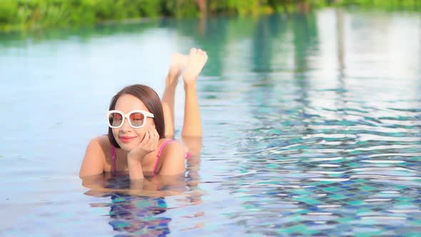 Young asian woman enjoy around outdoor swimming pool for leisure