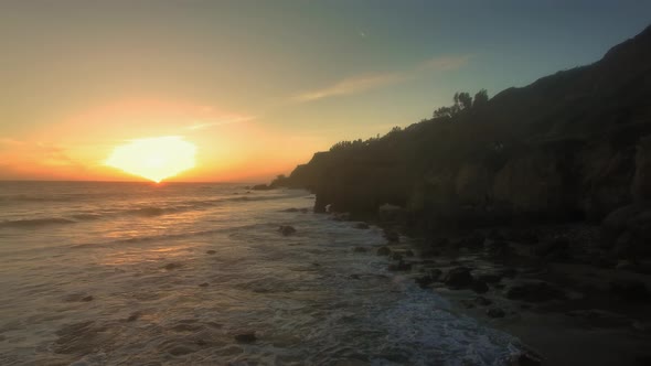 Aerial shot of foamy waves beating on the shore at El Matador Beach, Malibu, Califronia, USA