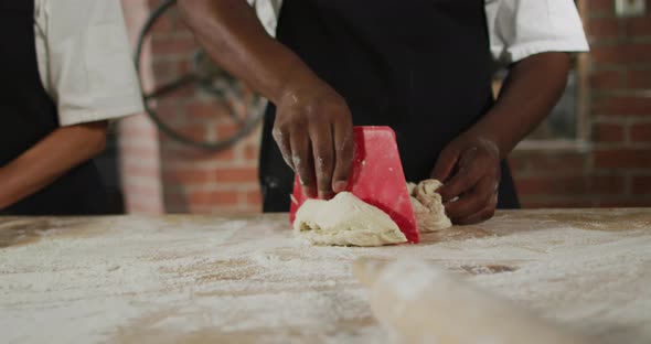 Animation of hands of diverse male and female bakers cutting sourdough for bread