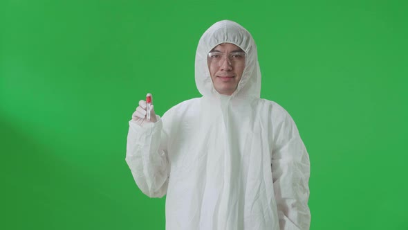 Asian Man Wearing Protective Uniform Ppe And Holding A Glass Of Test Tube In The Green Screen Studio