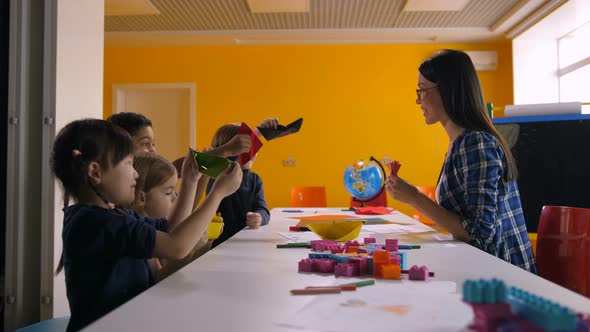 Joyful Children Playing with Handmade Paper Toy