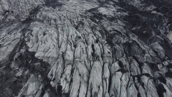 Aerial view overlooking dirty, melting glacier surface, caused by global warming - circling, drone s