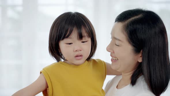 Asian family with mother holding and comforting crying son