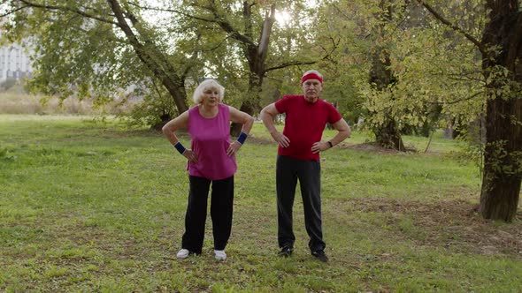 Active Senior Couple Doing Morning Stretching Physical Exercises in Park. Fitness Family Leisure