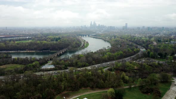 Aerial drone flying forward to view Philadelphia city skyline over the Schuylkill river and highway