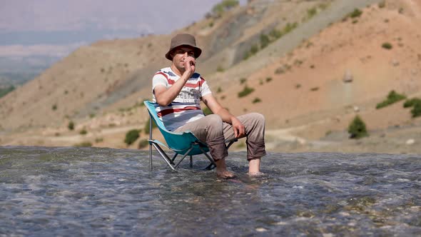 Young Vacationer Throwing Stones in Water