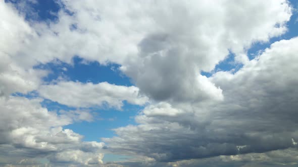 Aerial drone view White clouds fly across a bright blue sky