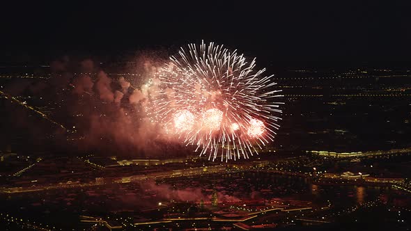 Red Bright Fireworks Over Night Cityscape with Reflection in the Rivers