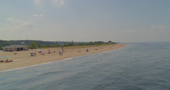 Flying Over Water and Towards Sandy Beach Shore on a Sunny Day in Long Island