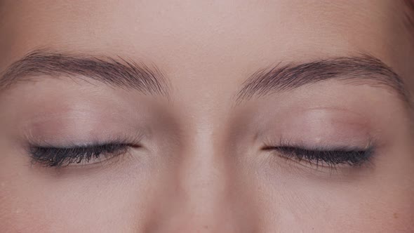 Close-up portrait of young, beautiful and natural woman opening her eyes.