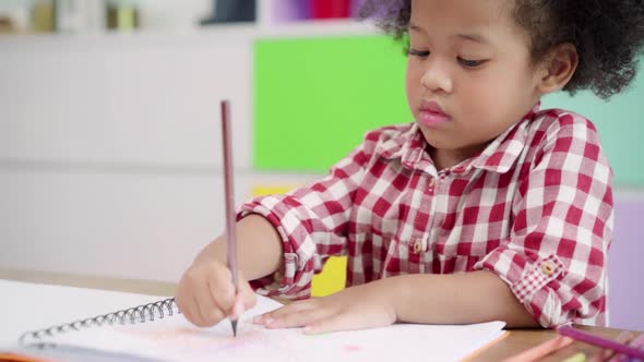 African kids drawing and do homework in classroom, young girl happy funny study and play painting.