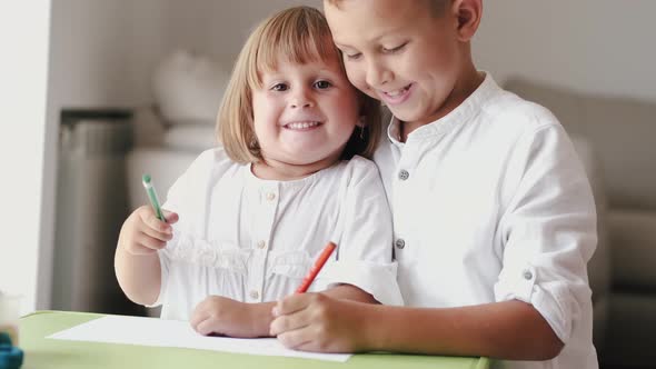 Portrait of Brother and Sister Sitting Together and Drawing at Home