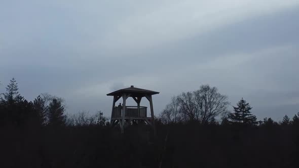 Flying with a drone towards a lookout tower to spot wildlife in De Hoge Veluwe National Park in The