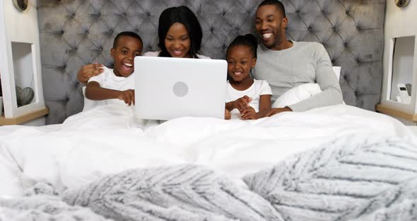 Family using laptop in bedroom 4k