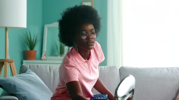 Young Black Woman Student Is Looking in Table Mirror