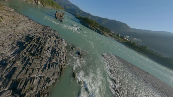 Aerial Dynamic View Speed Water Flow Mountain River Cliff Rocky Texture Island and Walking Bridge