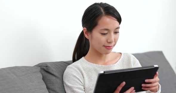 Woman reading on tablet computer at home