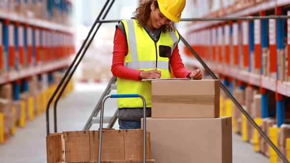 Female warehouse worker checking stock for shipping