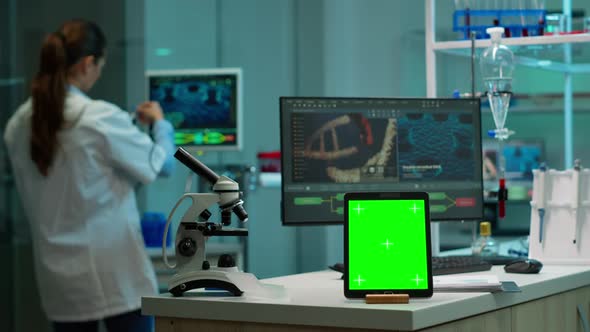 Team of Scientists Working in Background Using Tablet with Green Screen