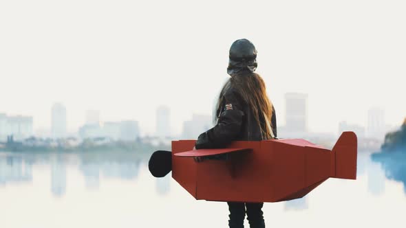 Little Pilot Girl in a Cardboard Plane