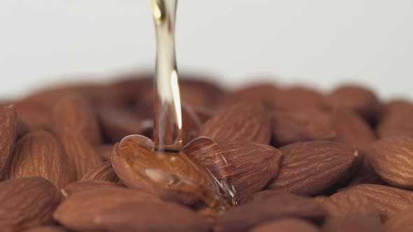 Pouring oil on almonds.Slow Motion.