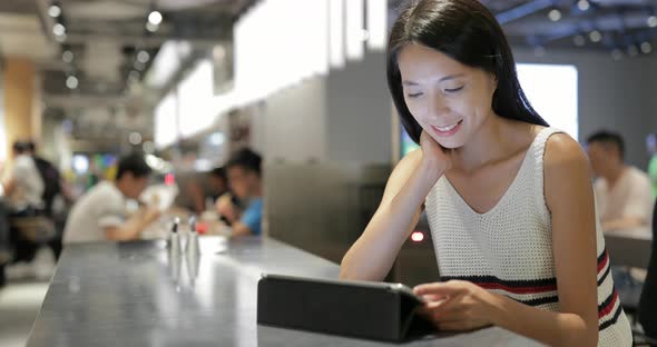 Woman Using Digital Tablet Computer in Restaurant 