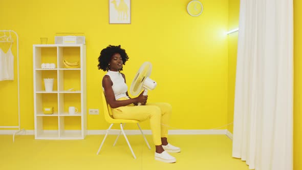 Portrait of Black Woman Relaxing In Yellow Office
