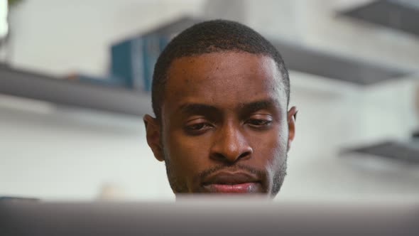 Young serious man receiving news chatting on the internet using laptop